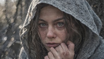 1girl,solo,looking at viewer,brown hair,brown eyes,closed mouth,green eyes,hand up,hood,medium hair,blurry,lips,depth of field,blurry background,clenched hand,portrait,snow,hood up,freckles,rain,snowing,realistic,nose,long hair,close-up,forehead