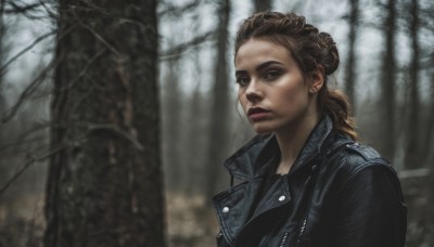 1girl,solo,long hair,brown hair,jewelry,jacket,upper body,earrings,outdoors,blurry,tree,lips,black jacket,blurry background,nature,forest,realistic,leather,bare tree,leather jacket,denim jacket,looking at viewer,brown eyes,closed mouth,dark skin,hair bun,mole,makeup,single hair bun,lipstick,freckles,stud earrings