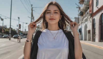 1girl,solo,long hair,looking at viewer,smile,brown hair,shirt,brown eyes,jewelry,closed mouth,jacket,white shirt,upper body,earrings,outdoors,sky,day,necklace,nail polish,blurry,bracelet,lips,black jacket,hands up,depth of field,blurry background,half-closed eyes,ring,ground vehicle,building,motor vehicle,hoop earrings,realistic,jacket on shoulders,car,road,holding hair,power lines,street,utility pole,road sign,photo background,bangs,holding,medium hair,blue sky,tattoo,thick eyebrows,cross,nose,bangle,cross necklace,cross earrings