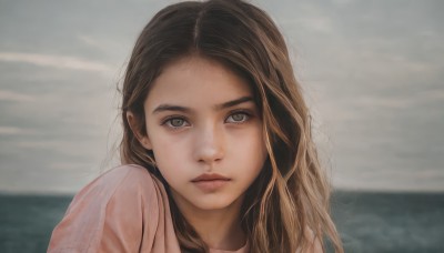 1girl,solo,long hair,looking at viewer,brown hair,shirt,brown eyes,closed mouth,white shirt,upper body,outdoors,sky,day,cloud,water,blurry,lips,grey eyes,blurry background,ocean,wavy hair,expressionless,cloudy sky,portrait,freckles,pink shirt,realistic,nose,horizon,grey sky,depth of field,close-up,forehead,overcast