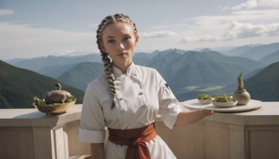 1girl,solo,long hair,looking at viewer,brown hair,holding,brown eyes,closed mouth,standing,white shirt,upper body,braid,outdoors,food,sky,day,blue sky,lips,sash,single braid,table,scenery,hair over shoulder,plate,bowl,braided ponytail,mountain,realistic,mountainous horizon,chef,short sleeves,cloud,sunlight,red sash,mole on cheek