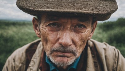 solo,looking at viewer,brown hair,shirt,black hair,1boy,hat,brown eyes,closed mouth,upper body,male focus,outdoors,sky,day,collared shirt,cloud,blurry,black eyes,blurry background,facial hair,cloudy sky,blue shirt,portrait,beard,brown jacket,realistic,mustache,brown headwear,manly,cowboy hat,tree,depth of field,scar,nature,serious