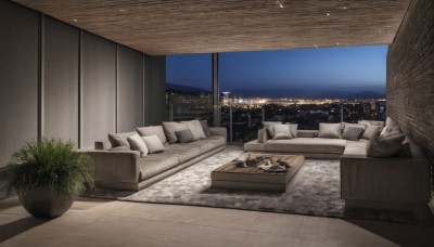 sky,indoors,cup,pillow,no humans,window,bed,night,chair,table,plant,curtains,building,night sky,scenery,couch,wooden floor,city,potted plant,lamp,cityscape,skyscraper,city lights,rug,skyline,book,shadow,tiles,on couch,tile floor,cushion,carpet