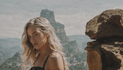 1girl,solo,long hair,looking at viewer,blue eyes,blonde hair,bare shoulders,jewelry,closed mouth,upper body,white hair,earrings,outdoors,sky,cloud,blurry,lips,blurry background,wavy hair,cloudy sky,mountain,realistic,grey sky,day,portrait,scenery,rock