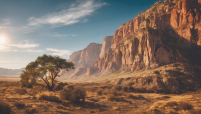 outdoors,sky,day,cloud,tree,blue sky,no humans,cloudy sky,grass,nature,scenery,forest,rock,mountain,sand,landscape,mountainous horizon,desert,sunlight,sun,cliff