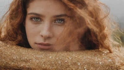 1girl,solo,long hair,looking at viewer,blue eyes,brown hair,closed mouth,outdoors,scarf,blurry,lips,grey eyes,eyelashes,wavy hair,portrait,close-up,freckles,curly hair,realistic,nose,green eyes