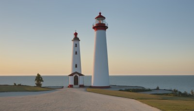 outdoors,sky,water,tree,blue sky,no humans,ocean,grass,building,scenery,horizon,road,house,castle,tower,day,beach,nature,sunset,sand,lighthouse