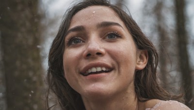 1girl,solo,long hair,looking at viewer,smile,open mouth,brown hair,outdoors,parted lips,teeth,grin,blurry,black eyes,tree,lips,depth of field,blurry background,portrait,nature,forehead,realistic,eyelashes,thick eyebrows,snow,close-up,freckles,nose,mole on cheek