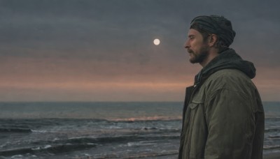 solo,short hair,black hair,1boy,hat,closed mouth,jacket,upper body,male focus,outdoors,sky,hood,water,from side,coat,profile,night,facial hair,ocean,beach,moon,hood down,beard,realistic,horizon,beanie,waves,cloud,hooded jacket,full moon,green jacket,mature male,mustache