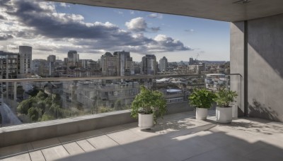 outdoors,sky,day,cloud,tree,blue sky,no humans,window,shadow,sunlight,cloudy sky,plant,building,scenery,city,potted plant,road,cityscape,wall,skyscraper,rooftop,skyline