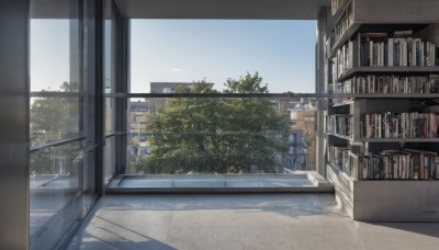 outdoors,sky,day,indoors,tree,book,no humans,window,shadow,plant,building,scenery,city,railing,bookshelf,cityscape,cloud,water,blue sky,reflective floor