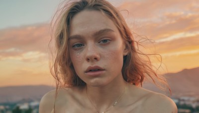 1girl,solo,long hair,looking at viewer,blue eyes,blonde hair,brown hair,bare shoulders,jewelry,collarbone,nude,outdoors,parted lips,sky,cloud,necklace,blurry,lips,depth of field,blurry background,messy hair,portrait,forehead,freckles,sunset,realistic,teeth,eyelashes,floating hair,thick eyebrows,wind