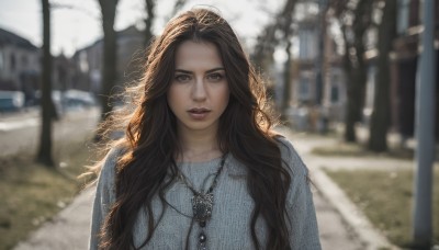 1girl,solo,long hair,looking at viewer,brown hair,shirt,black hair,brown eyes,jewelry,upper body,outdoors,parted lips,day,necklace,blurry,lips,dutch angle,depth of field,blurry background,wavy hair,blue shirt,snow,freckles,realistic,nose,road,teeth,messy hair,pendant,street,photo background