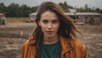 1girl,solo,long hair,looking at viewer,brown hair,shirt,brown eyes,jewelry,jacket,upper body,earrings,outdoors,parted lips,open clothes,day,blurry,open jacket,lips,depth of field,blurry background,wind,messy hair,freckles,brown jacket,realistic,nose,green shirt,teeth,tree,building,portrait,zipper,leather,orange jacket,photo background