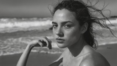 1girl,solo,long hair,looking at viewer,closed mouth,monochrome,upper body,greyscale,nude,outdoors,hand up,blurry,lips,blurry background,ocean,beach,portrait,freckles,realistic,nose,water