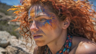 1girl,solo,long hair,blue eyes,brown hair,1boy,jewelry,outdoors,parted lips,sky,day,necklace,blurry,lips,depth of field,blurry background,wavy hair,messy hair,portrait,freckles,curly hair,rock,realistic,nose,facepaint,orange hair,eyelashes,floating hair,facial mark,looking away,wind,close-up,beads,looking afar,dirty