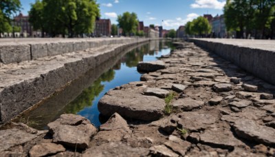 outdoors,sky,day,cloud,water,tree,blue sky,no humans,grass,building,scenery,reflection,rock,city,road,ruins,bridge,river,real world location,blurry,depth of field,cloudy sky,reflective water