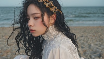 1girl,solo,long hair,looking at viewer,shirt,black hair,hair ornament,dress,white shirt,upper body,outdoors,parted lips,day,white dress,blurry,black eyes,from side,lips,grey eyes,depth of field,blurry background,ocean,wavy hair,beach,messy hair,portrait,curly hair,realistic,nose,sand,closed mouth,sky,water,blue sky,looking to the side,expressionless,photo background,shore