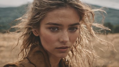 1girl,solo,long hair,looking at viewer,blonde hair,brown eyes,closed mouth,outdoors,day,blurry,lips,floating hair,depth of field,blurry background,wind,portrait,freckles,realistic,brown hair,sky,eyelashes,wavy hair,messy hair,close-up,dirty