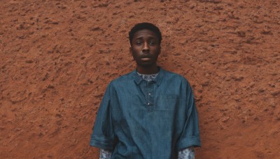 solo,looking at viewer,short hair,shirt,black hair,long sleeves,1boy,closed mouth,upper body,short sleeves,male focus,collared shirt,dark skin,black eyes,dark-skinned male,blue shirt,pocket,realistic,breast pocket,layered sleeves,short over long sleeves,very dark skin,photo background,white shirt,tattoo,brown background,orange background