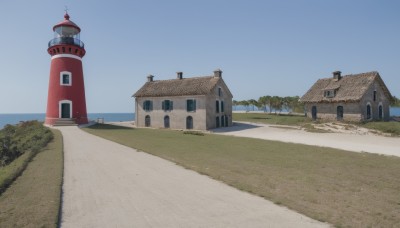 outdoors,sky,day,water,tree,blue sky,no humans,window,shadow,ocean,grass,building,scenery,horizon,road,bush,house,river,beach,sand,tower,shore,path,church