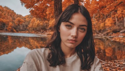 1girl,solo,long hair,looking at viewer,brown hair,shirt,black hair,brown eyes,closed mouth,white shirt,upper body,outdoors,day,water,tree,lips,nature,reflection,realistic,nose,autumn leaves,river,autumn,bangs,parted bangs,leaf,expressionless,thick eyebrows,portrait,scenery,forest,freckles