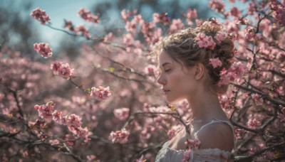 1girl, solo, short hair, brown hair, hair ornament, dress, bare shoulders, upper body, flower, outdoors, day, hair flower, hair bun, blurry, from side, tree, lips, profile, depth of field, blurry background, cherry blossoms, pink flower, realistic, branch, mole on neck