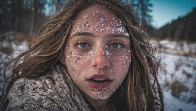 1girl,solo,long hair,looking at viewer,blue eyes,brown hair,outdoors,parted lips,teeth,day,scarf,blurry,tree,lips,grey eyes,depth of field,blurry background,portrait,snow,realistic,nose,winter,open mouth,water,eyelashes,close-up,forehead,freckles