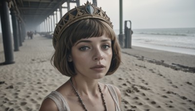 1girl,solo,looking at viewer,short hair,bangs,brown hair,brown eyes,jewelry,upper body,outdoors,parted lips,solo focus,day,necklace,mole,blurry,lips,grey eyes,blurry background,bob cut,tiara,crown,portrait,freckles,realistic,nose,collarbone,black eyes,gem