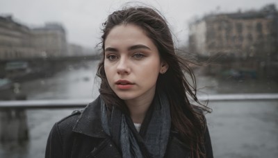 1girl,solo,long hair,looking at viewer,brown hair,jewelry,jacket,upper body,earrings,outdoors,parted lips,day,scarf,blurry,lips,black jacket,depth of field,blurry background,building,messy hair,freckles,realistic,leather,leather jacket,teeth,grey eyes,makeup,thick eyebrows,wind,portrait,bokeh,grey sky,denim jacket