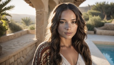 1girl,solo,long hair,breasts,looking at viewer,smile,brown hair,black hair,cleavage,brown eyes,closed mouth,collarbone,upper body,outdoors,day,dark skin,water,blurry,dark-skinned female,tree,lips,tattoo,blurry background,wavy hair,plant,freckles,curly hair,realistic,nose,dress,medium breasts,depth of field,sunlight,portrait,forehead,backlighting,pool