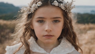 1girl,solo,long hair,looking at viewer,brown hair,hair ornament,brown eyes,closed mouth,flower,outdoors,day,hair flower,blurry,lips,depth of field,blurry background,wavy hair,portrait,freckles,realistic,nose,head wreath,parted lips,sky,expressionless,wind,veil,close-up