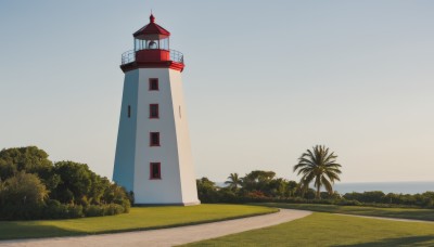 flower,outdoors,sky,day,tree,blue sky,no humans,beach,grass,plant,building,nature,scenery,sand,palm tree,road,bush,tower,path,horizon,gradient sky,lighthouse