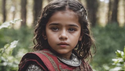 1girl,solo,long hair,looking at viewer,brown hair,black hair,brown eyes,closed mouth,upper body,outdoors,blurry,black eyes,tree,lips,depth of field,blurry background,child,portrait,nature,forest,freckles,curly hair,realistic,nose,day,close-up