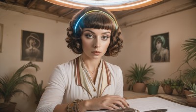 1girl,solo,looking at viewer,short hair,bangs,brown hair,shirt,brown eyes,jewelry,white shirt,upper body,hairband,indoors,dark skin,blunt bangs,necklace,bracelet,dark-skinned female,lips,book,eyelashes,headphones,plant,curly hair,realistic,nose,bangle,potted plant,photo (object),nail polish,black nails,watch,wristwatch