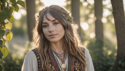 1girl,solo,long hair,looking at viewer,smile,brown hair,brown eyes,jewelry,closed mouth,upper body,outdoors,necklace,blurry,tree,lips,depth of field,blurry background,leaf,plant,nature,freckles,realistic,nose,head wreath,bokeh,day,mole,sunlight,portrait,forest