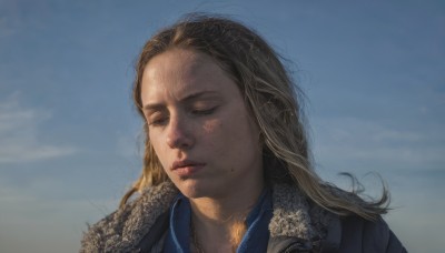 1girl,solo,long hair,blonde hair,brown hair,jewelry,closed mouth,jacket,closed eyes,outdoors,parted lips,sky,day,cloud,necklace,mole,blue sky,lips,fur trim,blue shirt,portrait,freckles,realistic,nose,coat,forehead,mole on cheek