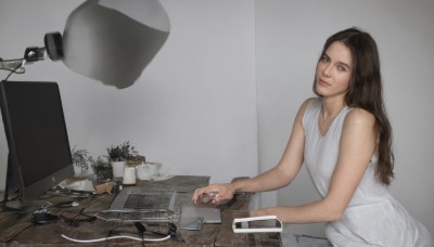 1girl,solo,long hair,looking at viewer,brown hair,dress,bare shoulders,brown eyes,sitting,closed mouth,sleeveless,indoors,white dress,cup,lips,sleeveless dress,table,plant,freckles,realistic,potted plant,lamp,cable,computer,monitor,keyboard (computer),mouse (computer),science fiction