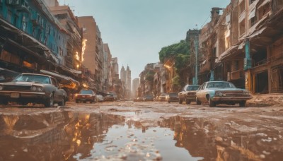 outdoors,sky,day,water,tree,blue sky,no humans,ground vehicle,building,scenery,motor vehicle,snow,reflection,city,car,road,ruins,winter,vehicle focus,lamppost,street,truck,real world location,fire,bridge,puddle,vanishing point