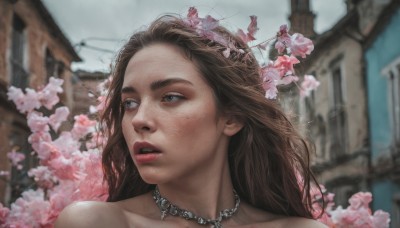 1girl,solo,long hair,blue eyes,brown hair,hair ornament,bare shoulders,jewelry,flower,outdoors,parted lips,teeth,day,hair flower,necklace,blurry,lips,looking to the side,blurry background,looking away,building,portrait,pink flower,freckles,realistic,sky,cherry blossoms